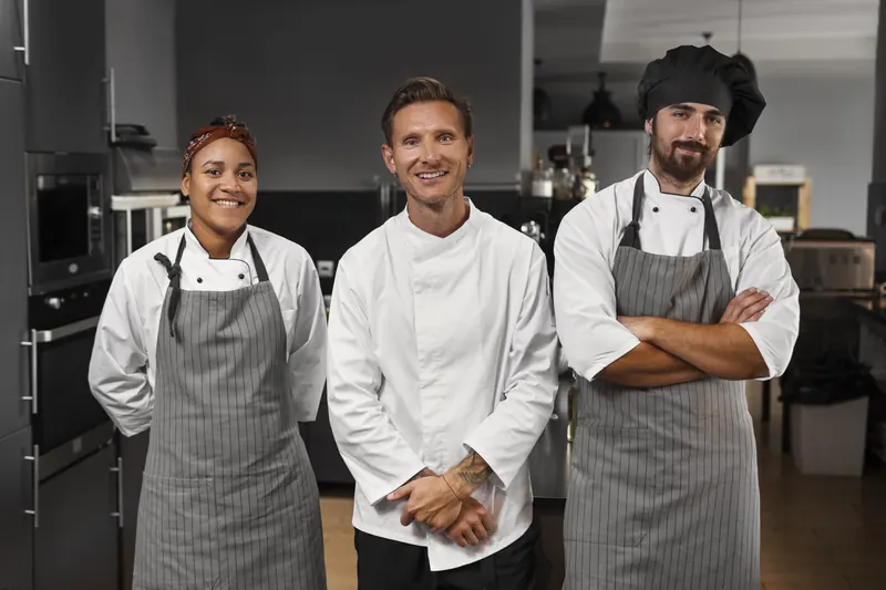 Kitchen team in matching chef coats and aprons
